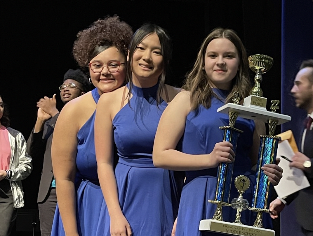  Girls pose on stage with a trophy